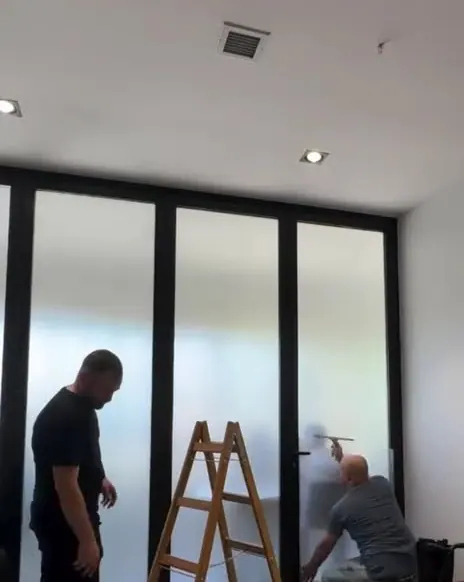 Ekip, ofis cam bölmelerine kumlama filmi uyguluyor